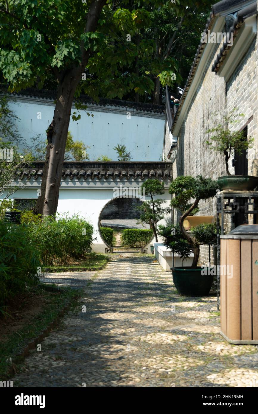 Porte ronde traditionnelle chinoise à côté des décorations dans la ville fortifiée de Kowloon à Hong Kong Banque D'Images