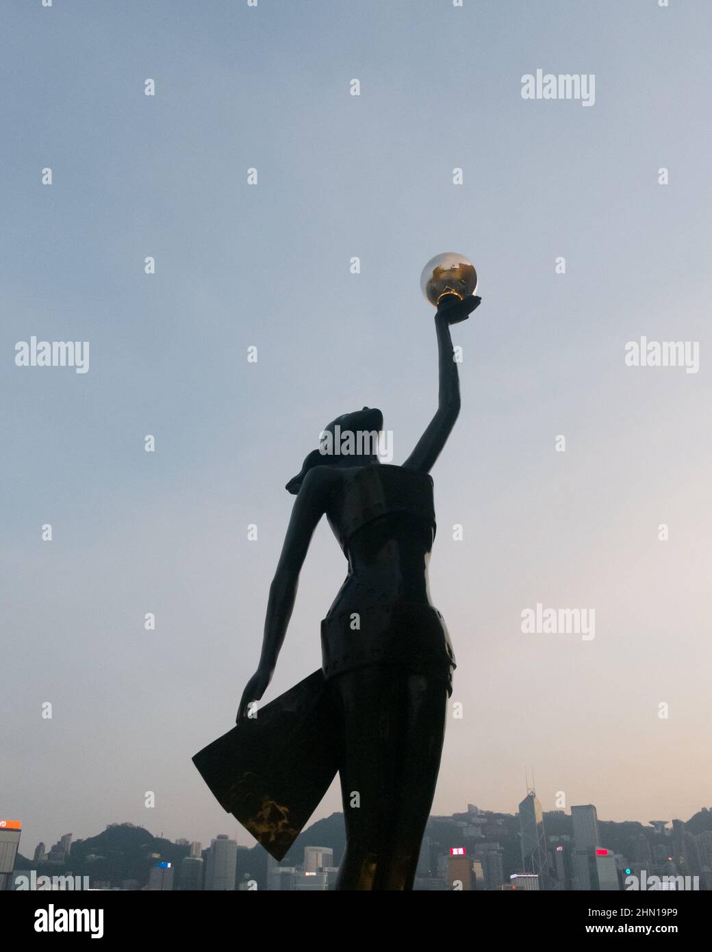 Statue des Hong Kong film Awards au coucher du soleil avec coucher du soleil et paysage urbain de Hong Kong derrière Banque D'Images