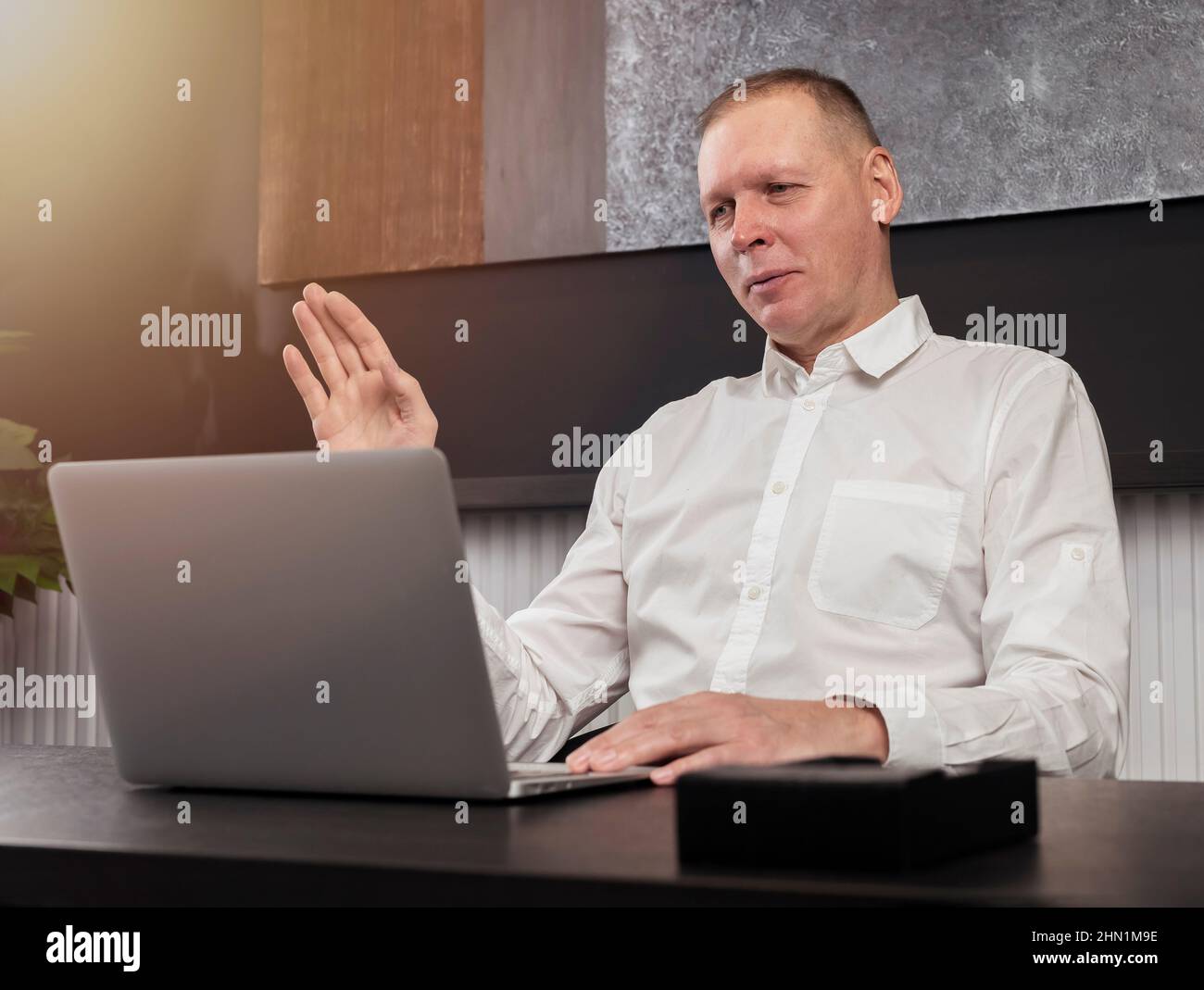 Homme d'affaires au PC portable saluant les pme lors de la visioconférence au bureau, concept de communication en ligne. Photo de haute qualité Banque D'Images