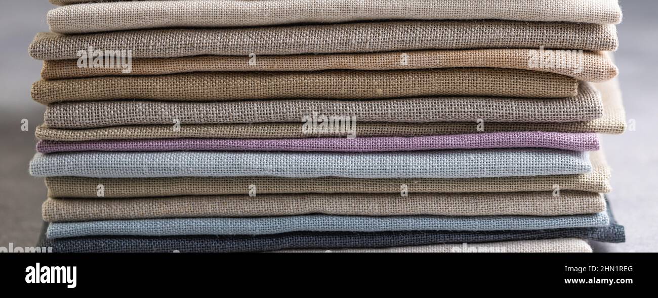 Un tas de quatre plié mat-couleur écologique linge naturel sur un fond rustique, bannière Banque D'Images