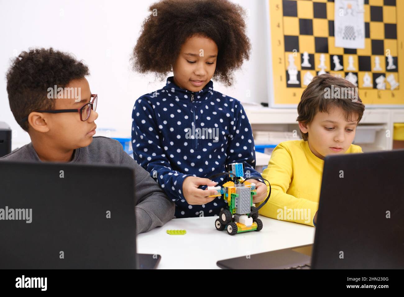 Les enfants apprennent le codage, la science et la technologie en classe scolaire. Des enfants afro-américains et caucasiens ont été cloués avec des ordinateurs portables dans la LEÇON STEM Banque D'Images