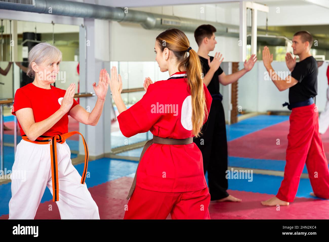 Femme âgée qui scinde avec une fille pendant la formation en arts martiaux Banque D'Images