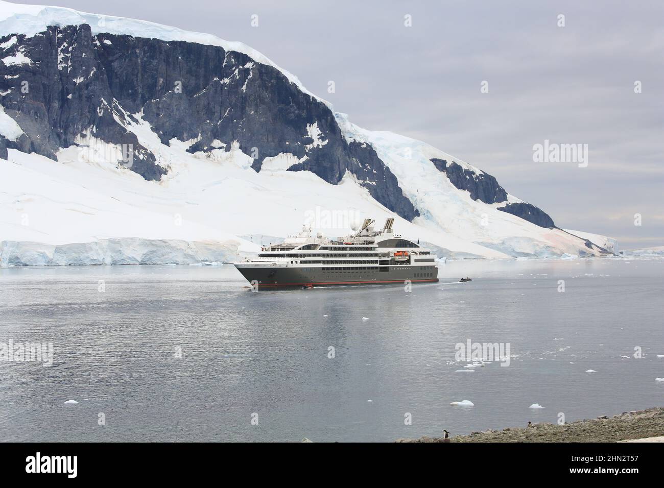Bateau de croisière le Boreal transportant des passagers en bateaux de zodiaque vers l'île Danco, avec Range Island en arrière-plan, l'Antarctique. Banque D'Images