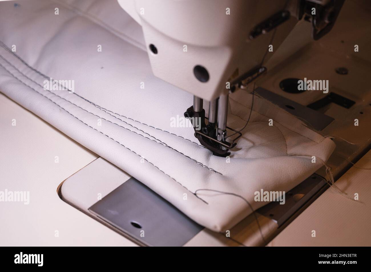 Usiner les points de suture dans les caissons en tissu blanc clair en atelier Banque D'Images