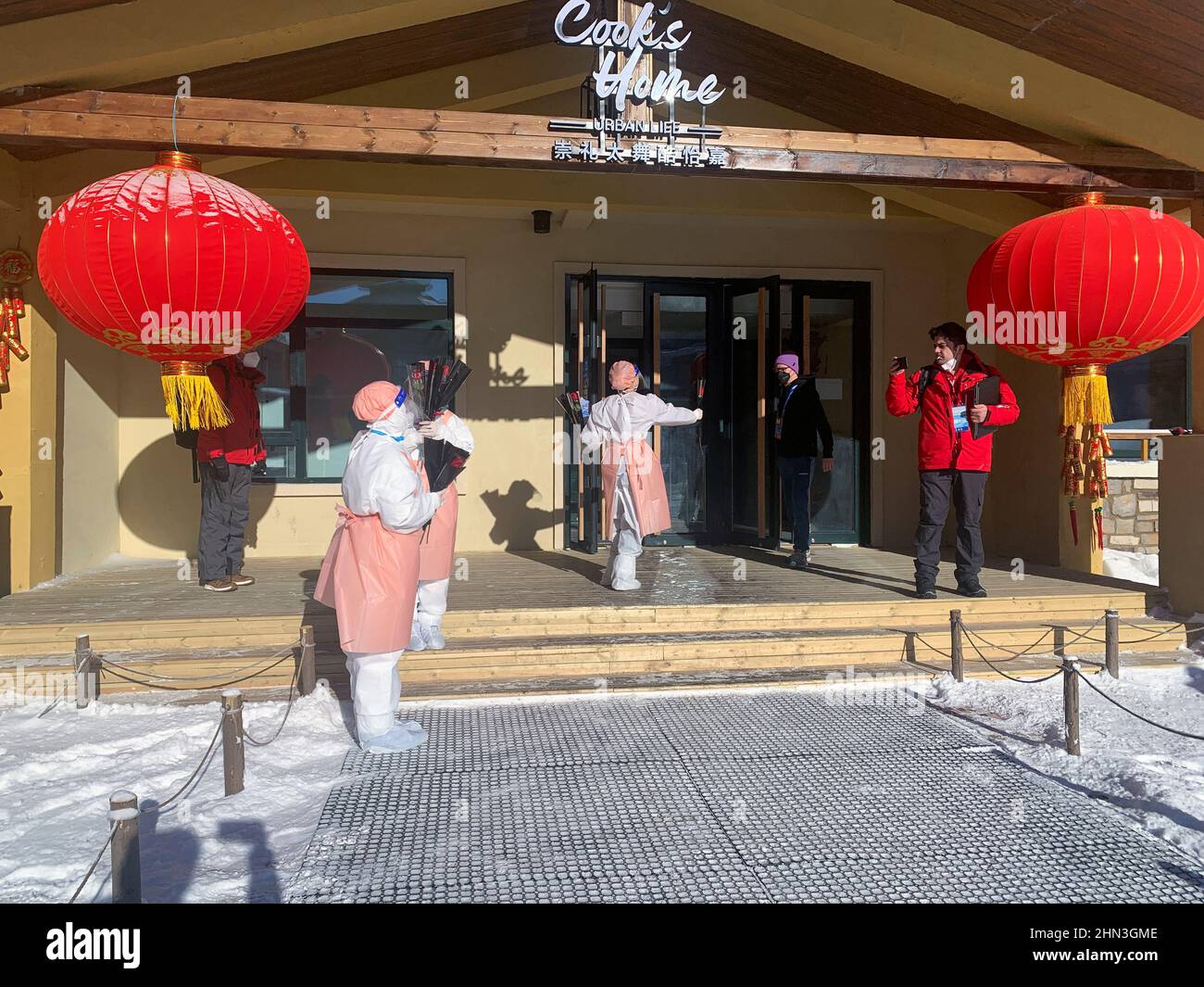 Les volontaires des Jeux Olympiques d'hiver de 2022 à Beijing donnent une seule rose rouge aux journalistes et au personnel quittant un hôtel en boucle fermée le jour de la Saint-Valentin, dans la station de ski de Thaliwoo à Zhangjiakou, en Chine, le 14 février 2022. REUTERS/Emily Roe Banque D'Images