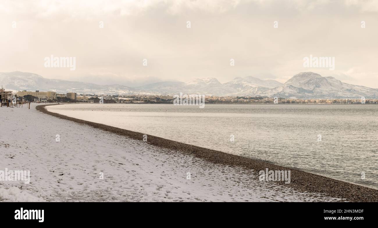 Plage enneigée à Loutraki en Grèce. Un phénomène rare et beau. Banque D'Images