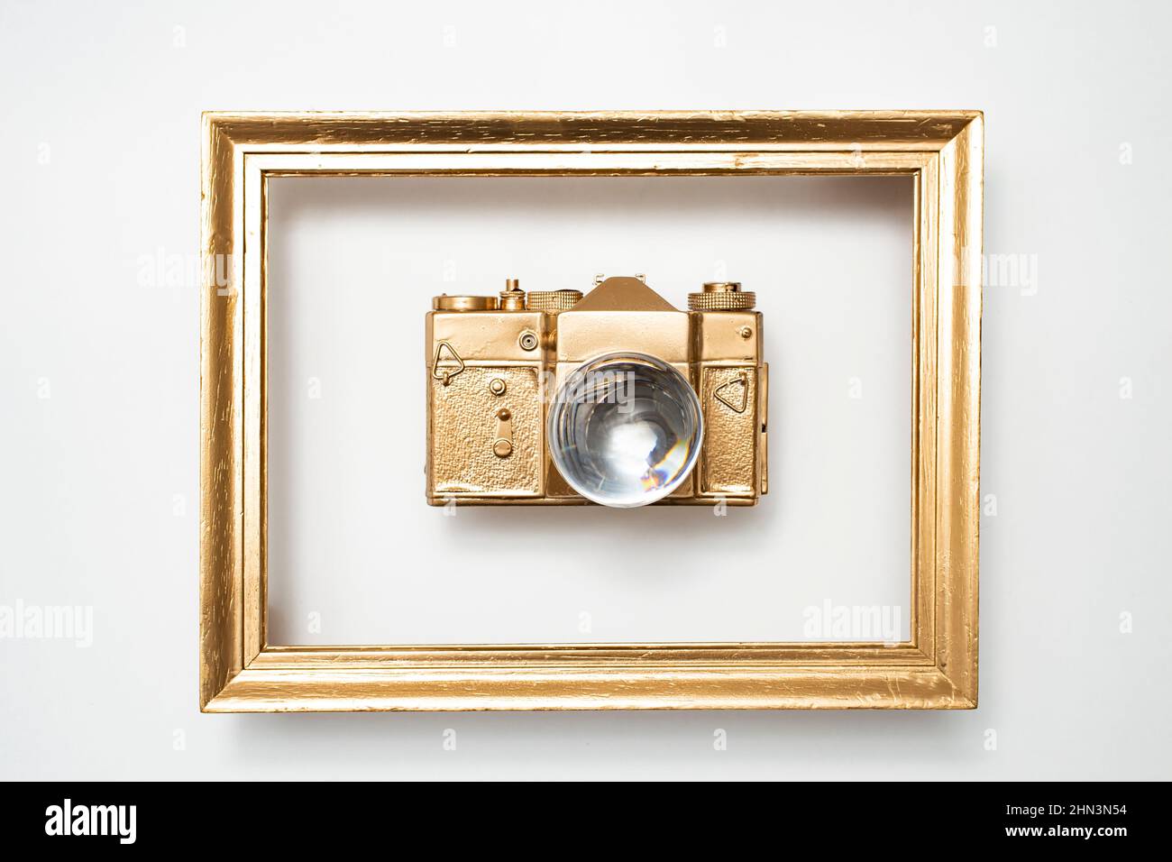 Appareil photo doré dans un cadre doré, avec une boule d'objectif au lieu  de l'objectif de l'appareil photo. Faible profondeur de champ Photo Stock -  Alamy