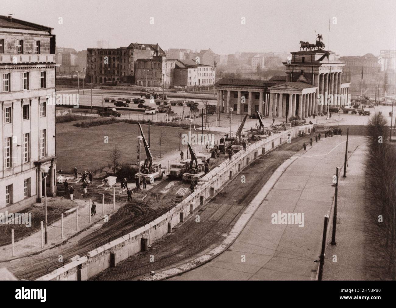 Photo vintage de la crise de Berlin de 1961: Construire le mur de Berlin renforcé. Sous l'œil attentif de la police communiste, les travailleurs de l'Allemagne de l'est se trouvent à proximité Banque D'Images