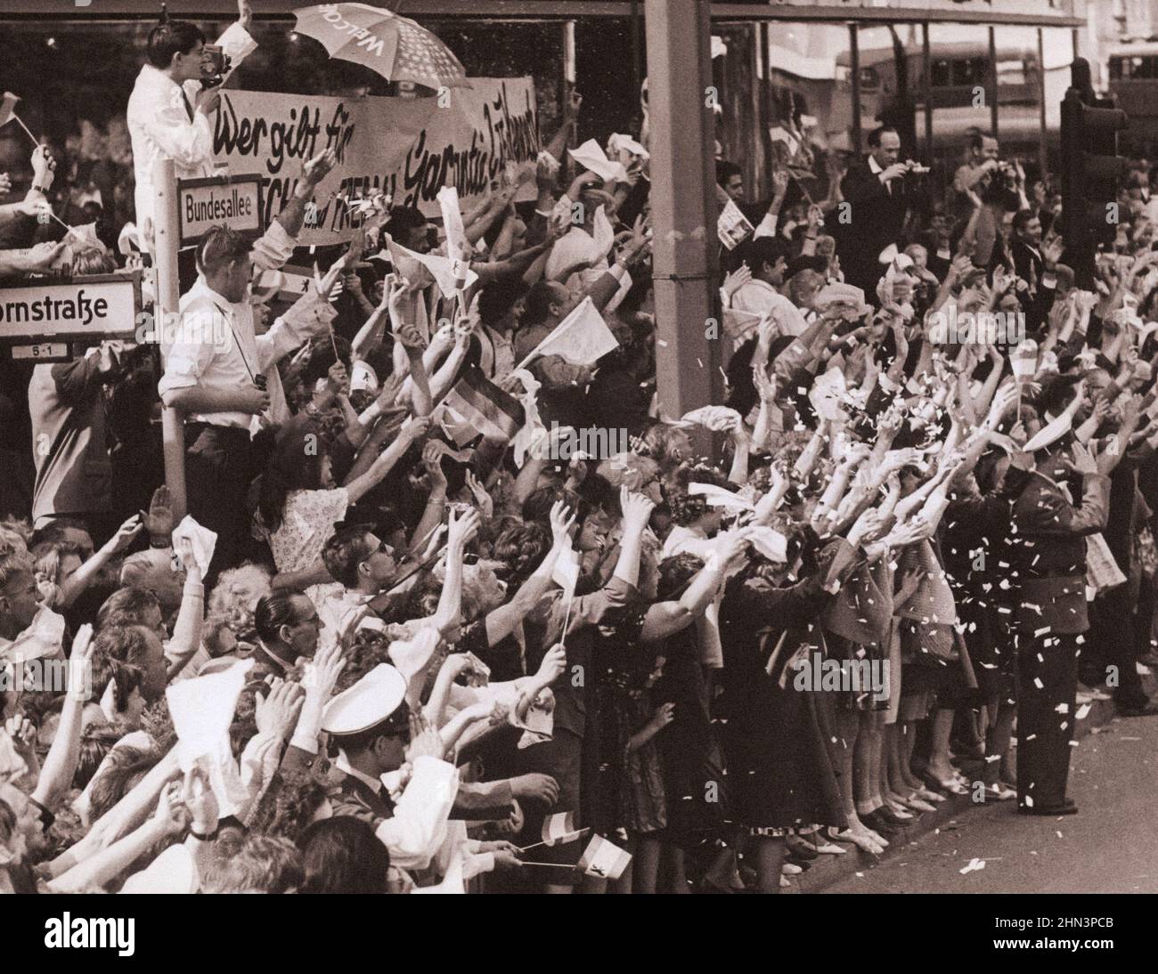 Photo d'époque de la crise de Berlin de 1961 : construire le mur. La foule de la rue de Berlin fait la vague d'accueil au moment où le président passe. Berlin Ouest. Juin 26, 1961 Banque D'Images