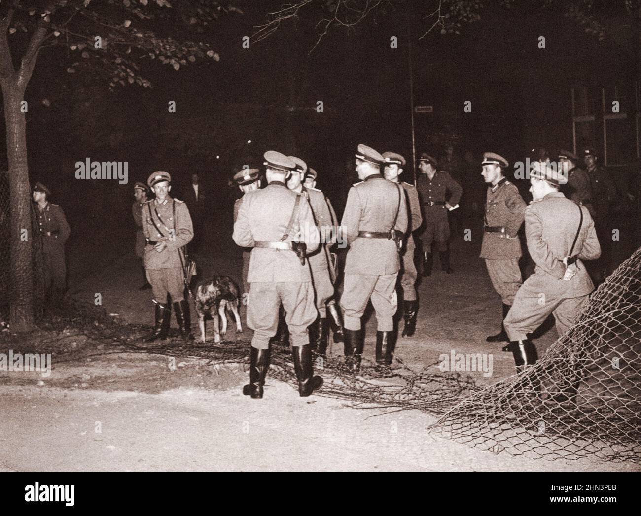 Photo d'époque de la crise de Berlin de 1961 : construire le mur. Police de l'Allemagne de l'est (communiste) à la frontière est-ouest de l'Allemagne où Barbedwire a été coupé par E Banque D'Images