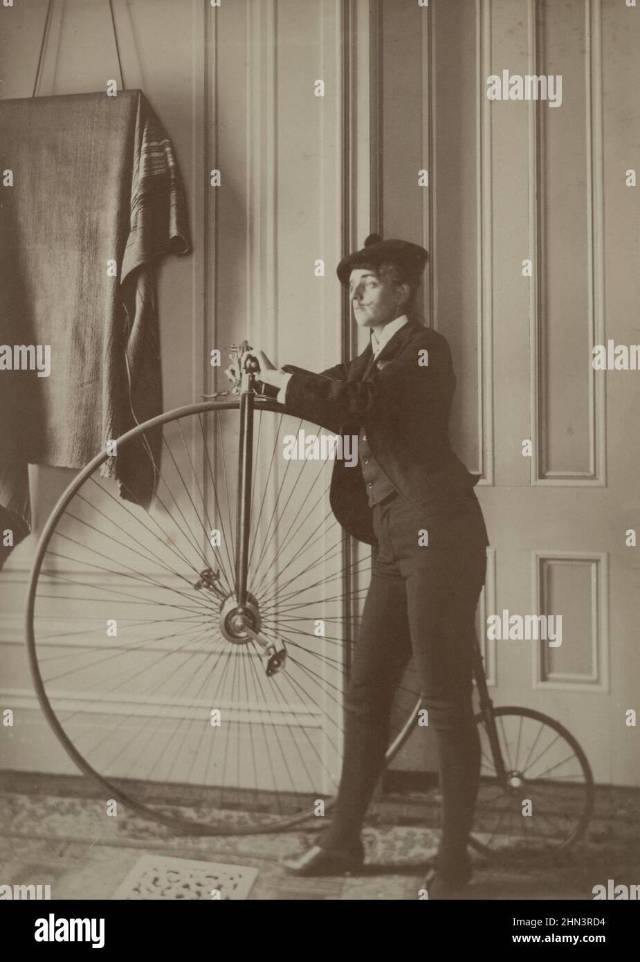 Photo vintage de Frances Benjamin Johnston (photographe), autoportrait habillé comme un homme avec fausse moustache, posé avec vélo. Entre 1890-1900 Banque D'Images
