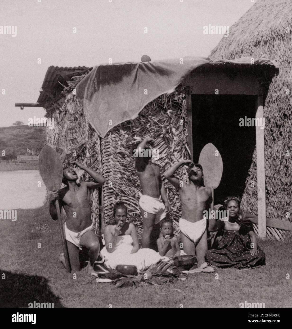 Photo d'époque d'un groupe de Kanaka Maoli mangeant poi, îles hawaïennes (en face de la hutte d'herbe). 1896 les autochtones hawaïens sont la Polynésie indigène Banque D'Images