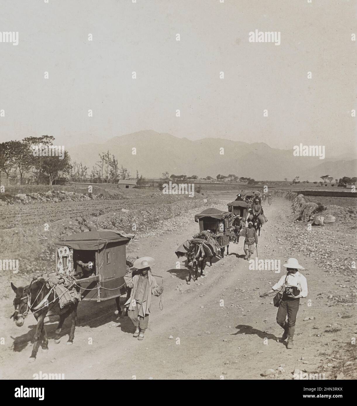 Photo vintage des hommes chinois en robe traditionnelle et charrettes à ânes sur le chemin des tombeaux de la dynastie Ming. Chine du Nord. Novembre 1902 Banque D'Images