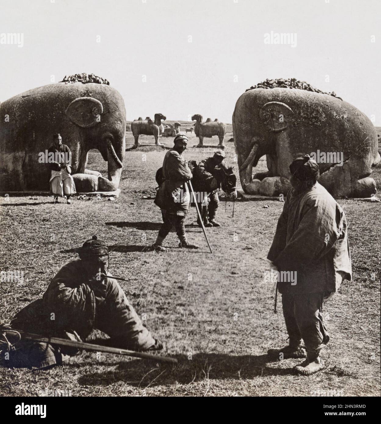 Photo d'époque des fermiers chinois près de l'énorme figure en pierre des éléphants dormanteurs. Tumbs Ming. Nanking, Chine du Nord. 1919 Banque D'Images