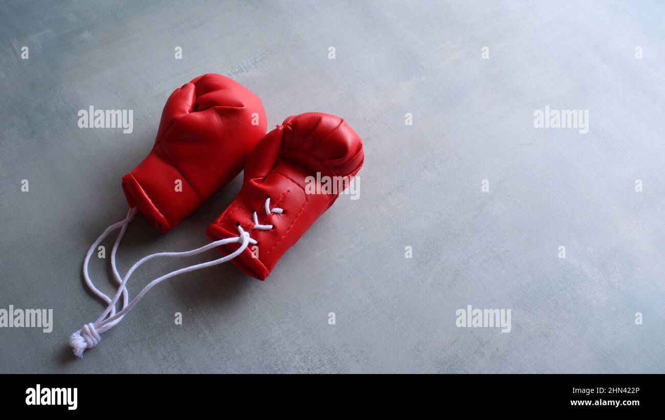Concept d'entraînement sportif. Gants de boxe rouges sur sol en béton avec espace pour le texte Banque D'Images
