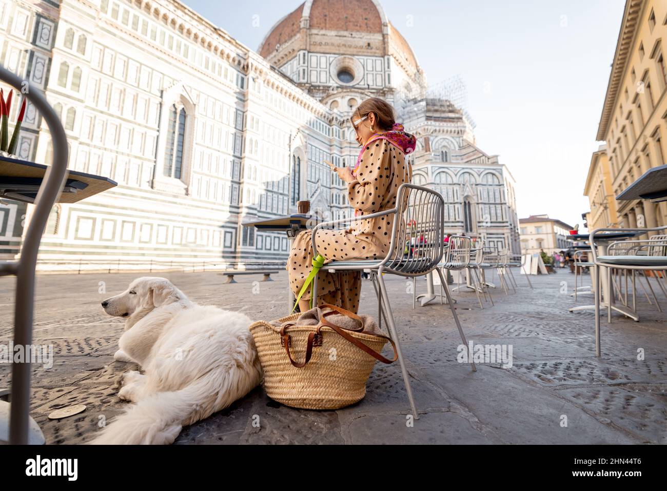 Femme assise avec son chien sur la terrasse du café près de la célèbre cathédrale Duomo à Florence Banque D'Images