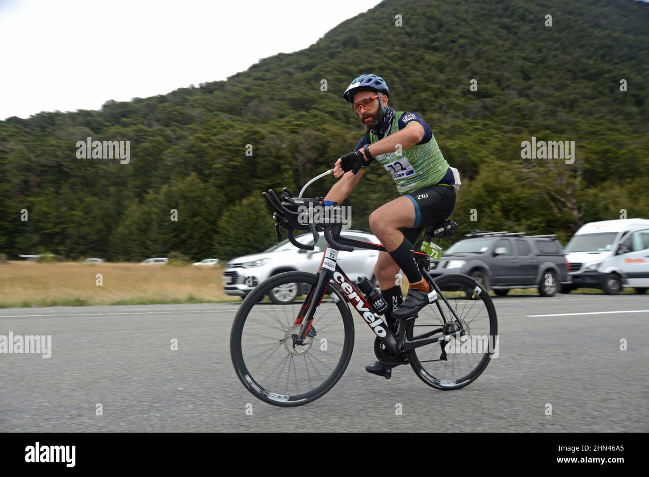 ARTHURS PASS, NOUVELLE-ZÉLANDE, 12 FÉVRIER 2022 ; le concurrent 72 vérifie sa montre alors qu'il quitte le Klondike Corner pour une section de vélo 115km du triathlon d'un océan à l'autre Banque D'Images