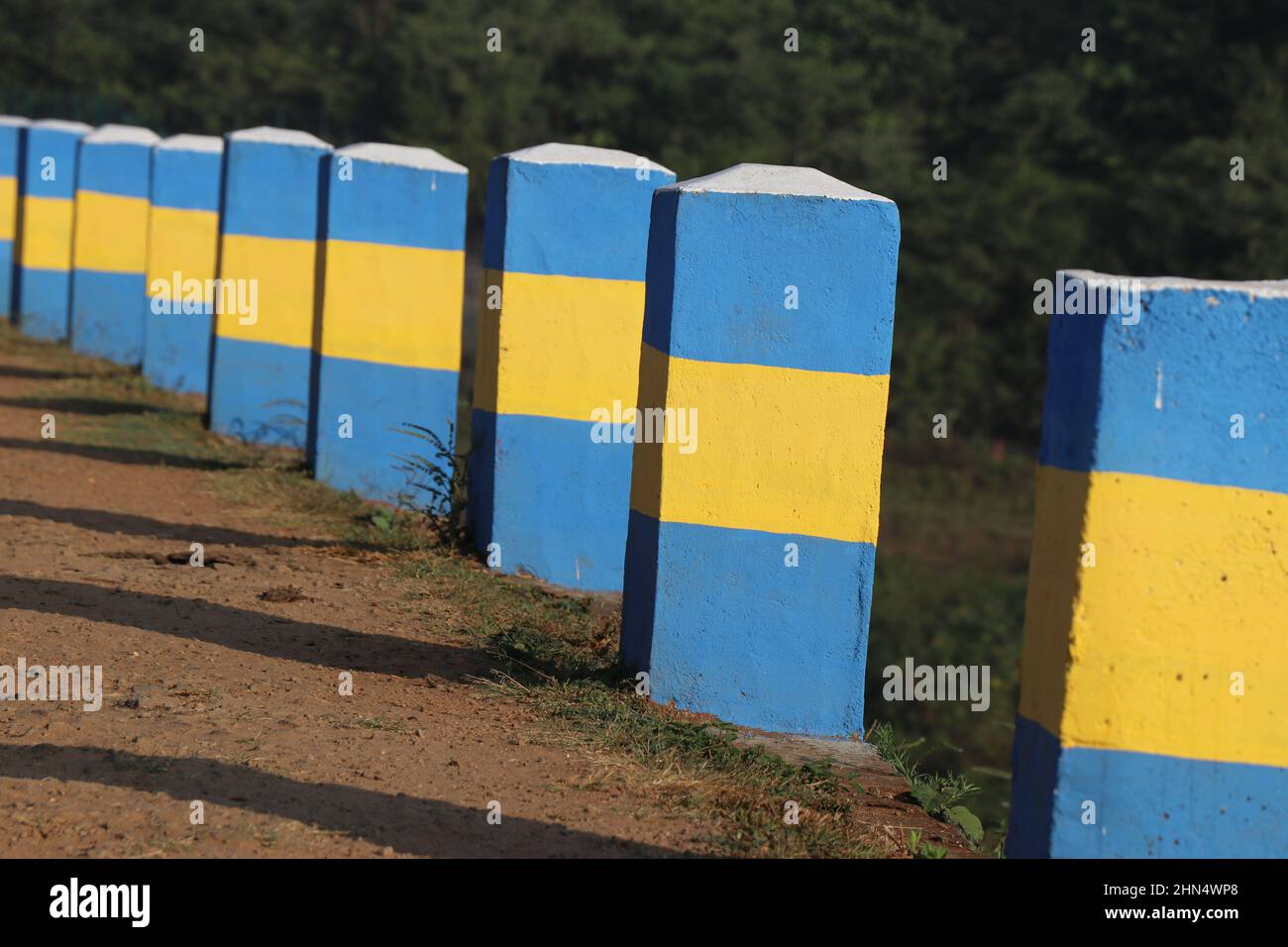 Blocs de béton à la barrière sur le côté de la route qui brillent au soleil Banque D'Images