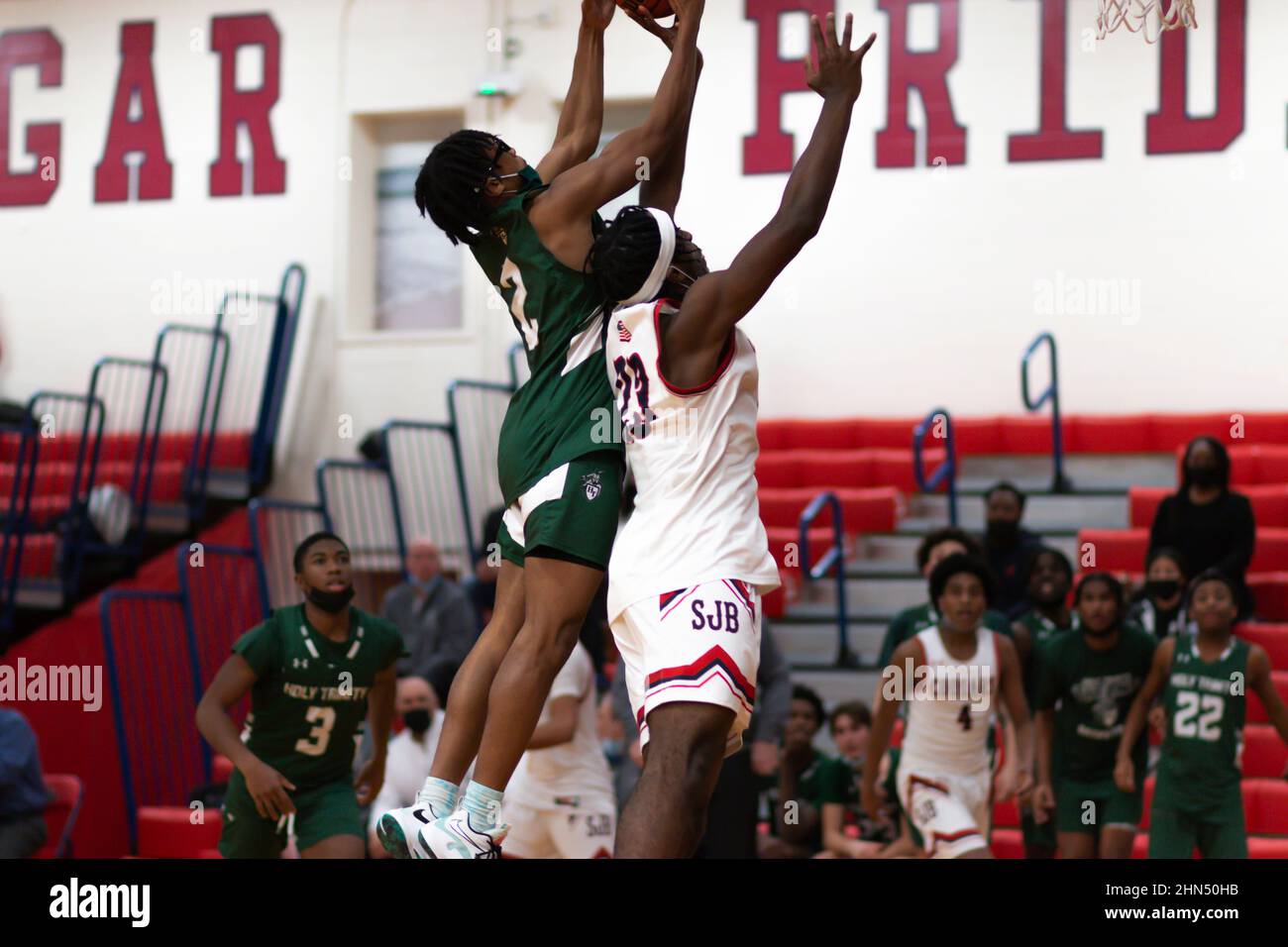 West Isp, New York, Etats-Unis - 2 février 2022 : un joueur de basket-ball de lycée qui a frappé le ballon sous le ballon, bloquant les tirs du Banque D'Images