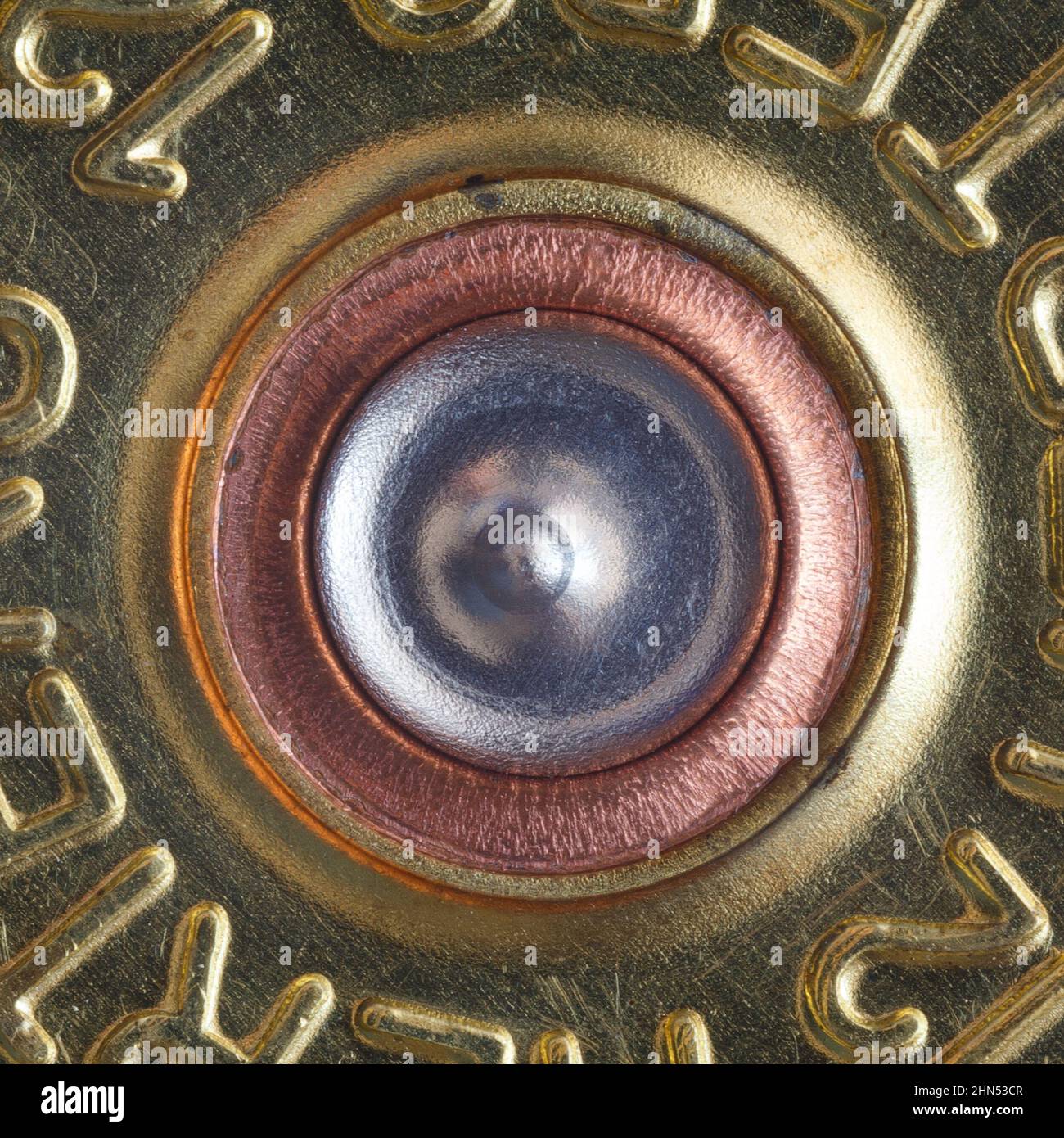 Un apprêt percé dans un étui de calibre 12 d'un fusil de chasse. Macrophotographie Banque D'Images