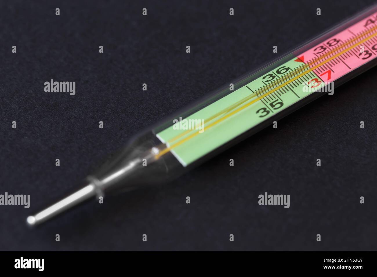 Thermomètre au mercure avec échelle bicolore sur fond sombre. Gros plan avec faible profondeur de champ Banque D'Images