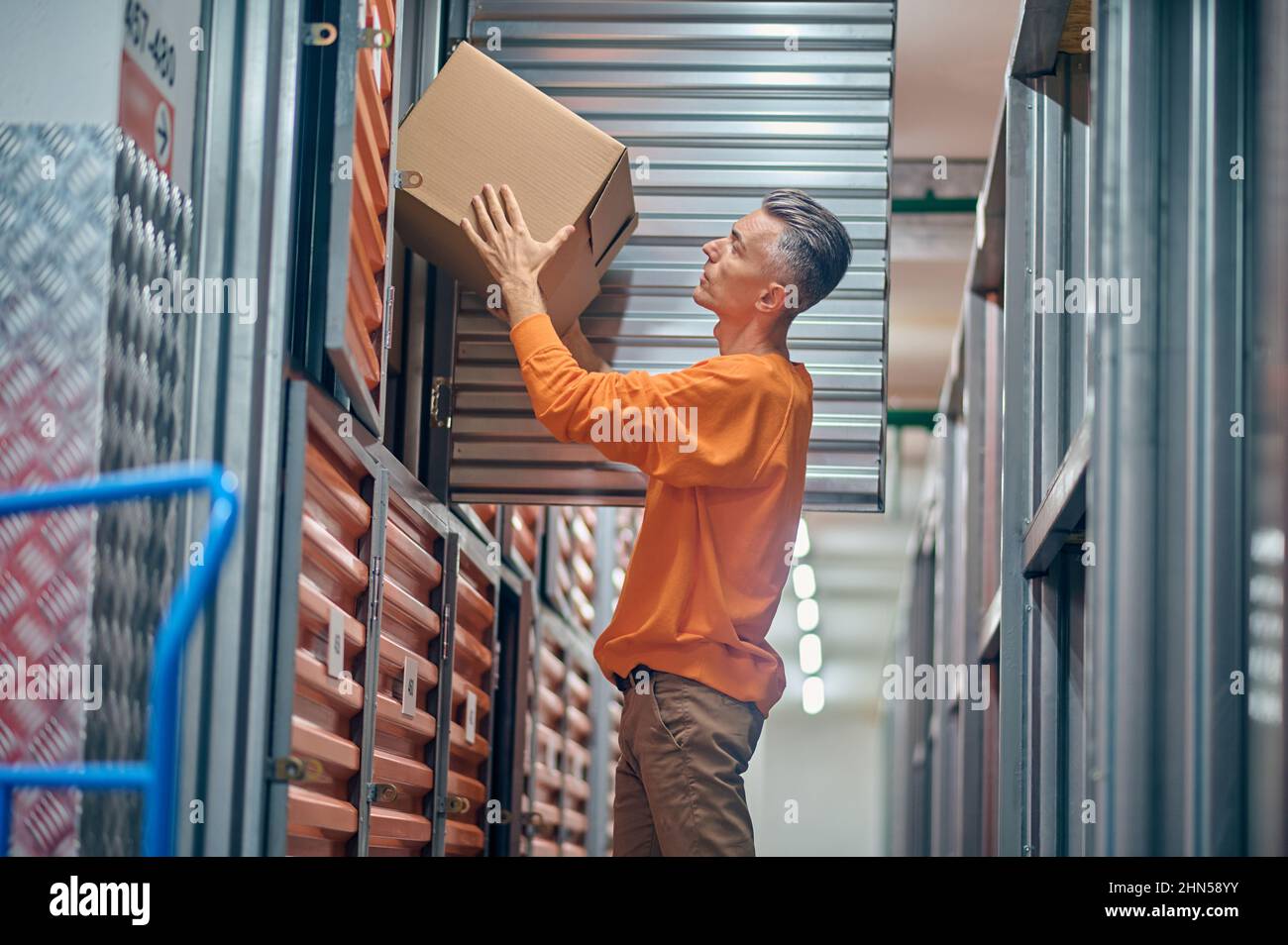 Employé d'entrepôt concentré déchargeant des marchandises à l'intérieur Banque D'Images