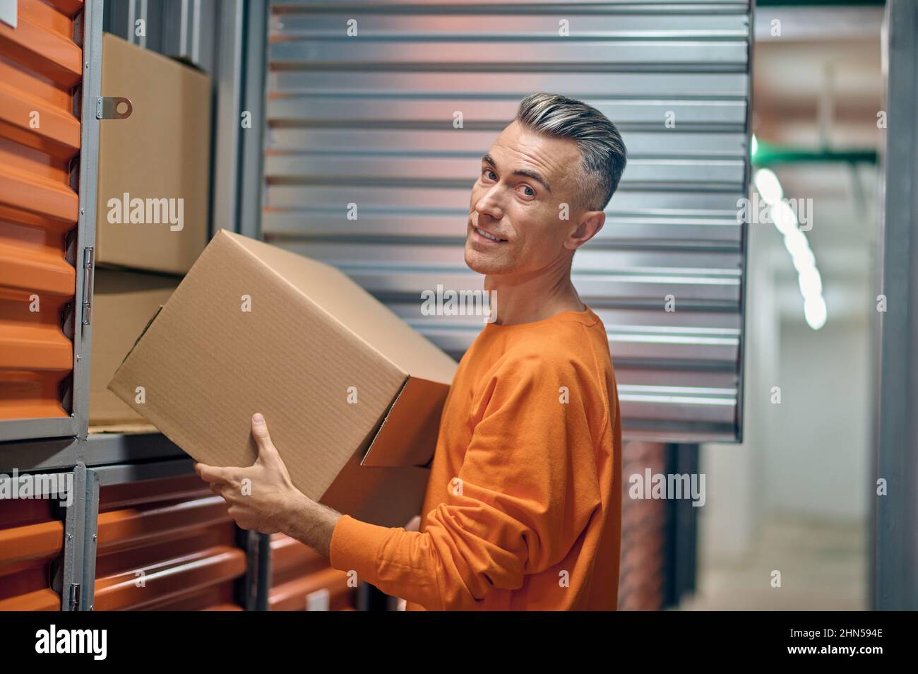 Un employé d'entrepôt joyeux qui se charge de la collecte des marchandises pour l'expédition Banque D'Images
