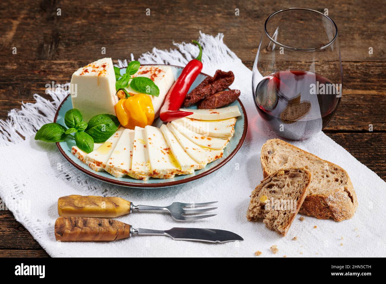 Plateau de fromages. Assiette de fromage doux frais garni de tomates séchées, de basilic et de piments. Banque D'Images