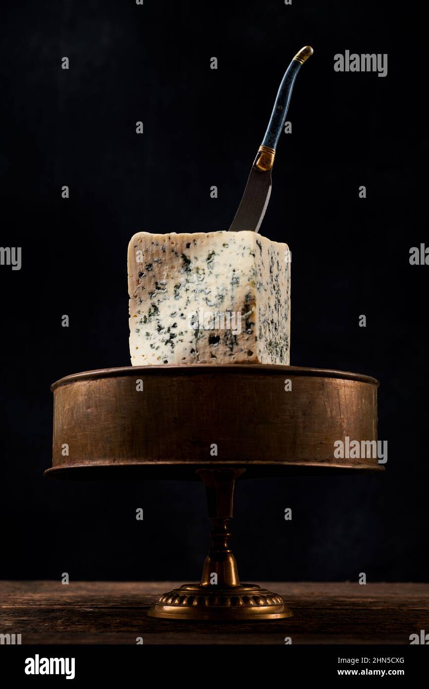 Bloc de fromage bleu sur fond sombre. Photo de la nourriture rustique sombre au fromage bleu. Banque D'Images