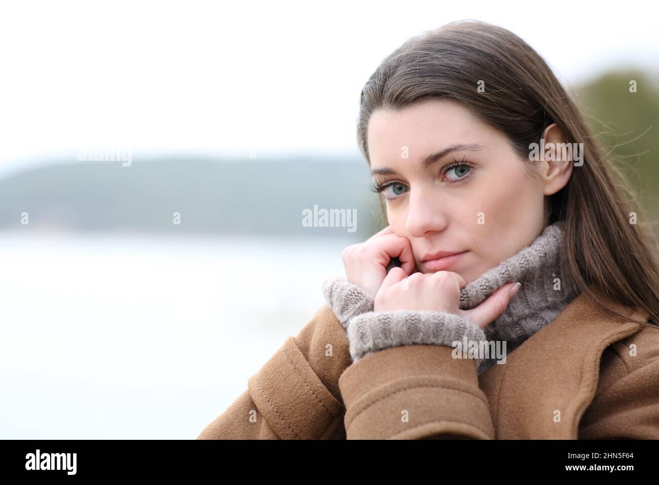 Portrait d'une femme sérieuse qui vous regarde en hiver dans un lac Banque D'Images