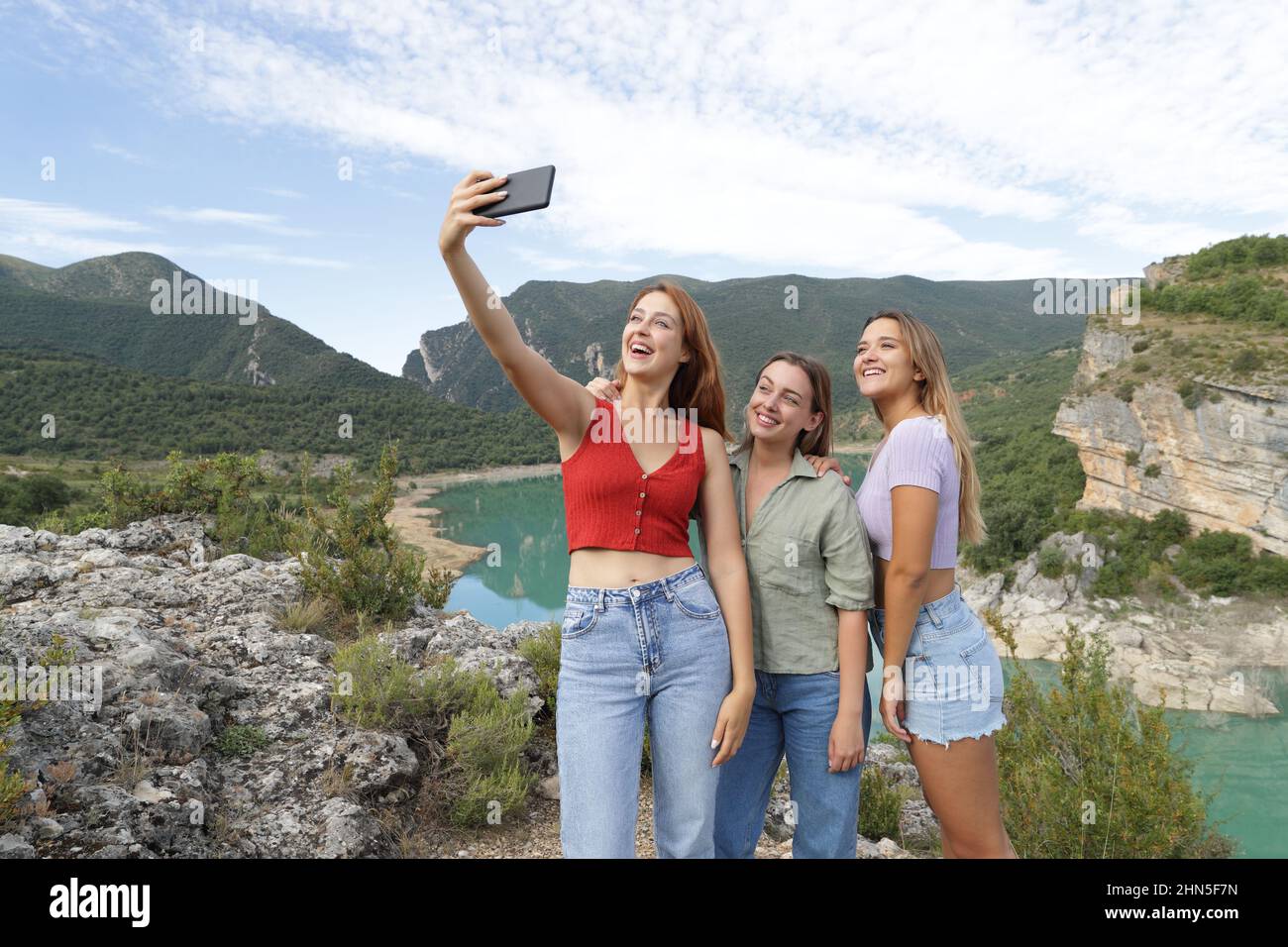 Trois amis heureux prenant le selfie avec un smartphone dans la montagne pendant les vacances d'été Banque D'Images