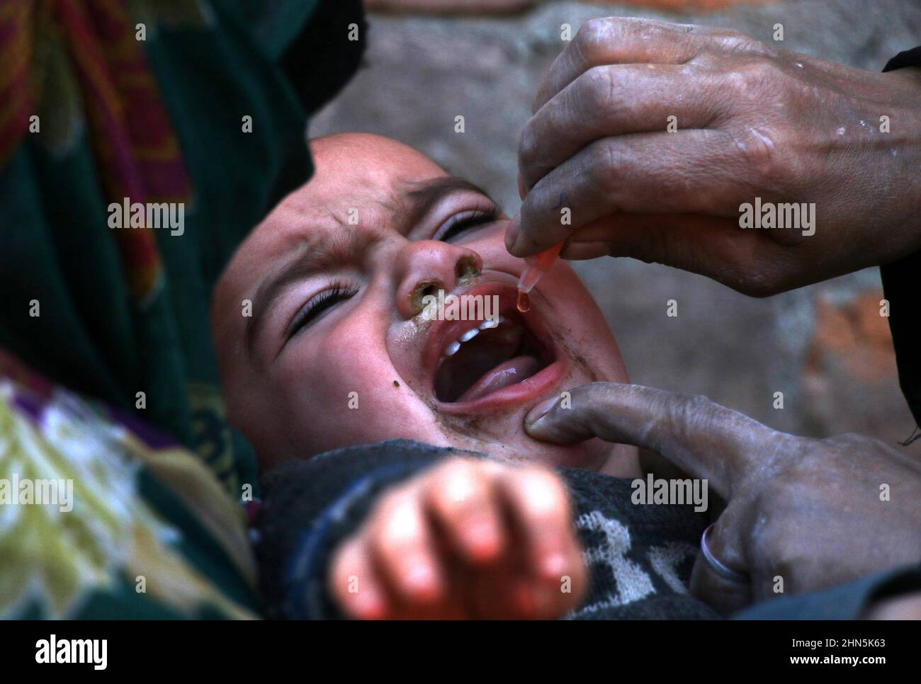 Un agent de santé administre le vaccin contre la polio à un réfugié afghan dans son camp de la périphérie d'Islamabad, au Pakistan, le 27 janvier 2022. Pakistan 1 Banque D'Images