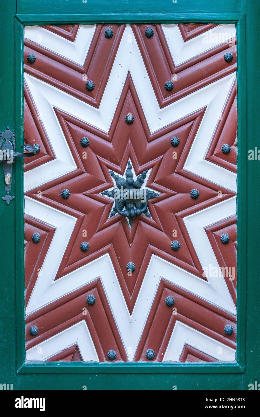 Une vieille porte européenne avec un motif saisissant de garnitures en bois créant une étoile. Banque D'Images