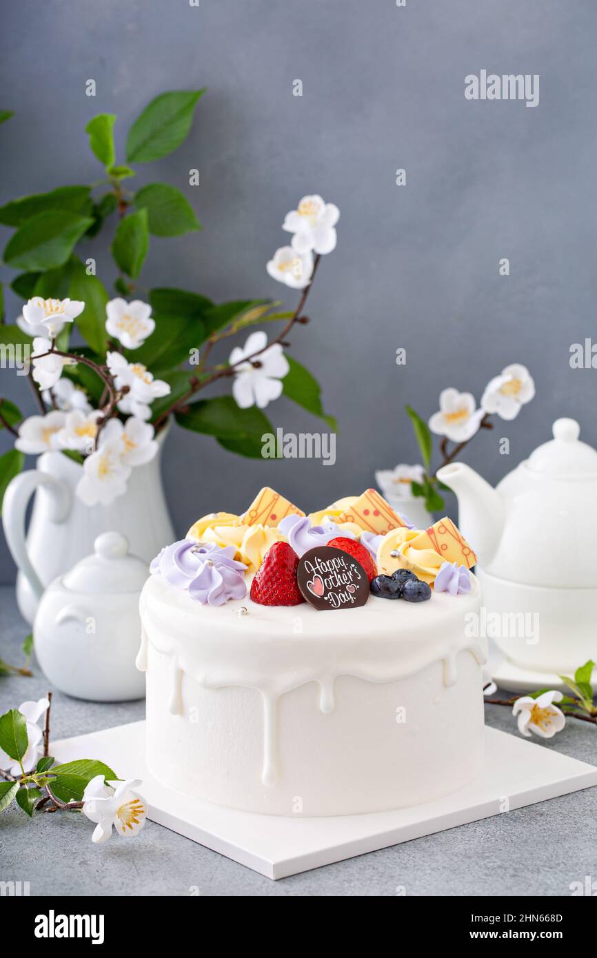Gâteau à la vanille pour la fête des mères avec fleurs et glaçage au chocolat blanc Banque D'Images