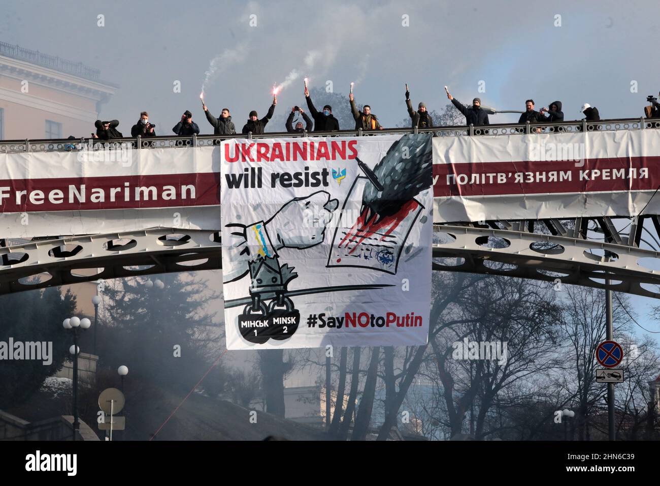 KIEV, UKRAINE - le 12 FÉVRIER 2022 - les gens brûlent des fusées éclairantes sur le pont piétonnier qui traverse l'allée Heavenly Hundred Heroes, près de Maidan Nezalezhnosti dur Banque D'Images