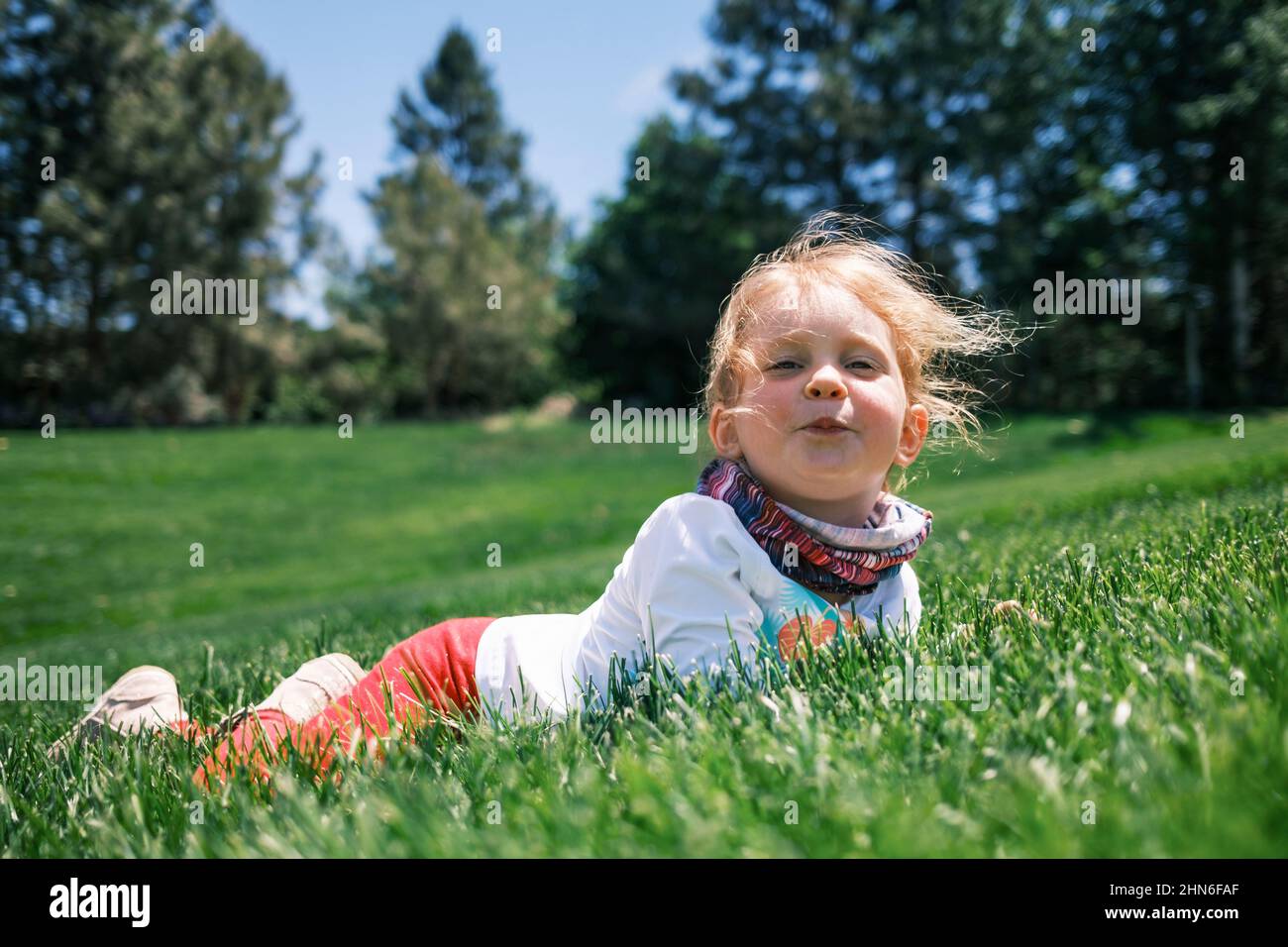 Petite fille allongée dans l'herbe (été 5-6 ans) Stock Photo