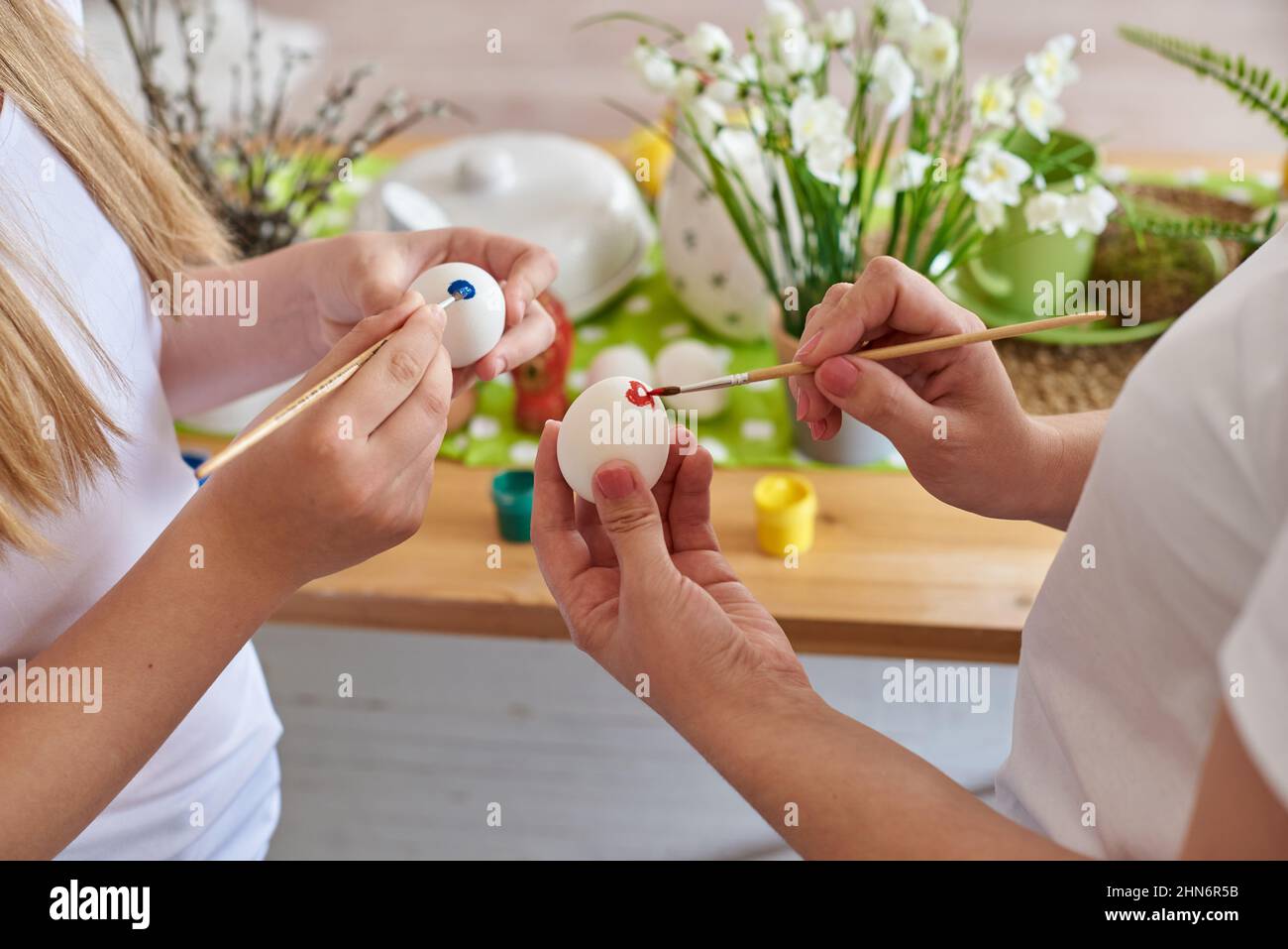Les mains colorant les œufs de pâques gros plan. Banque D'Images