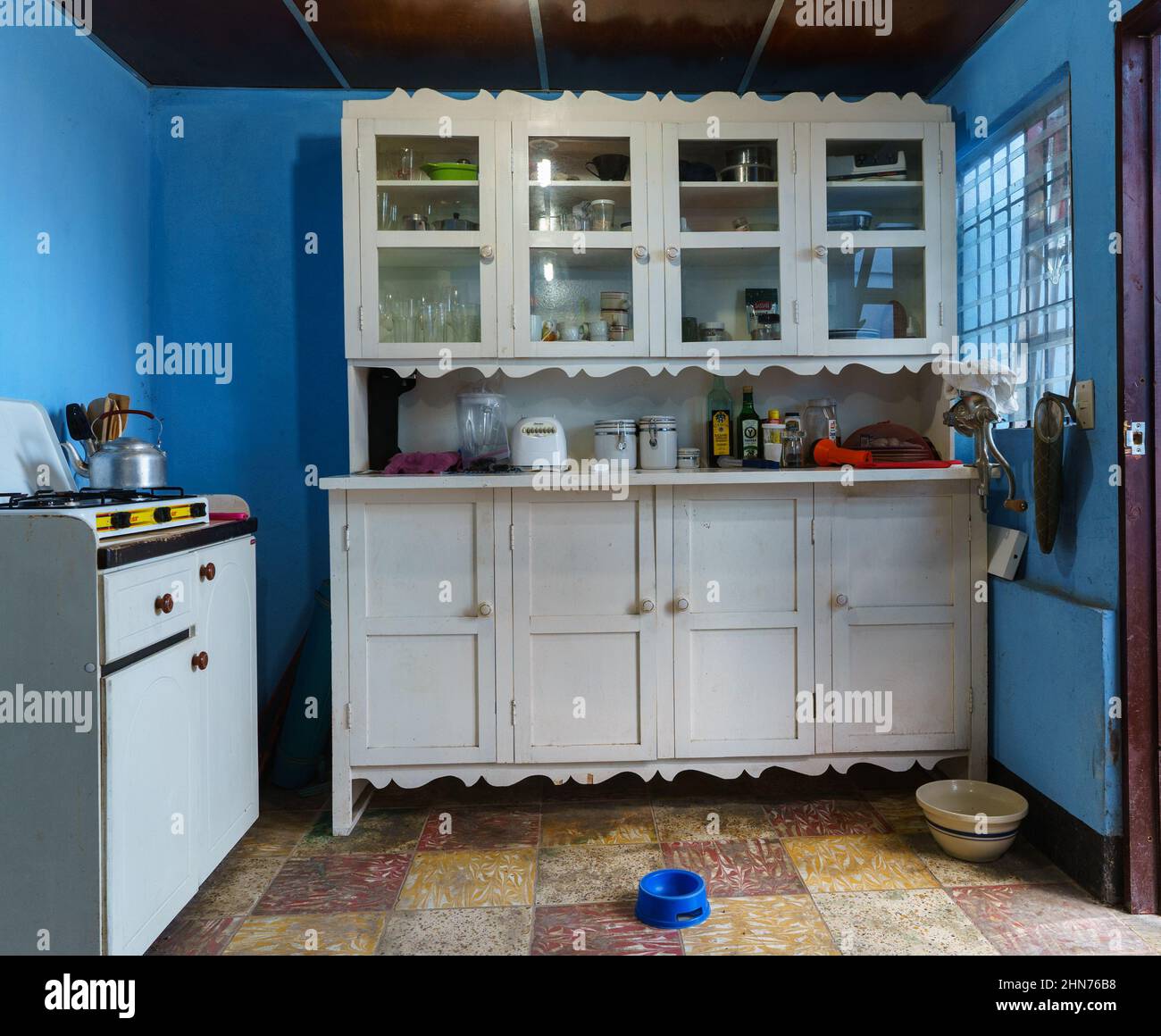 Intérieur d'une cuisine du Nicaragua avec buffet et table de cuisson sur la table de cuisson armoire avec des plats pour chiens sur le sol à Jinotega, Nicaragua. Banque D'Images