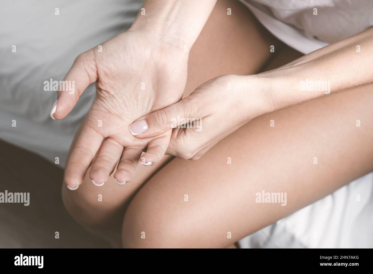 Engourdissement de la main ou engourdissement du membre. Femme souffrant de douleurs aux mains et aux doigts après le sommeil Banque D'Images