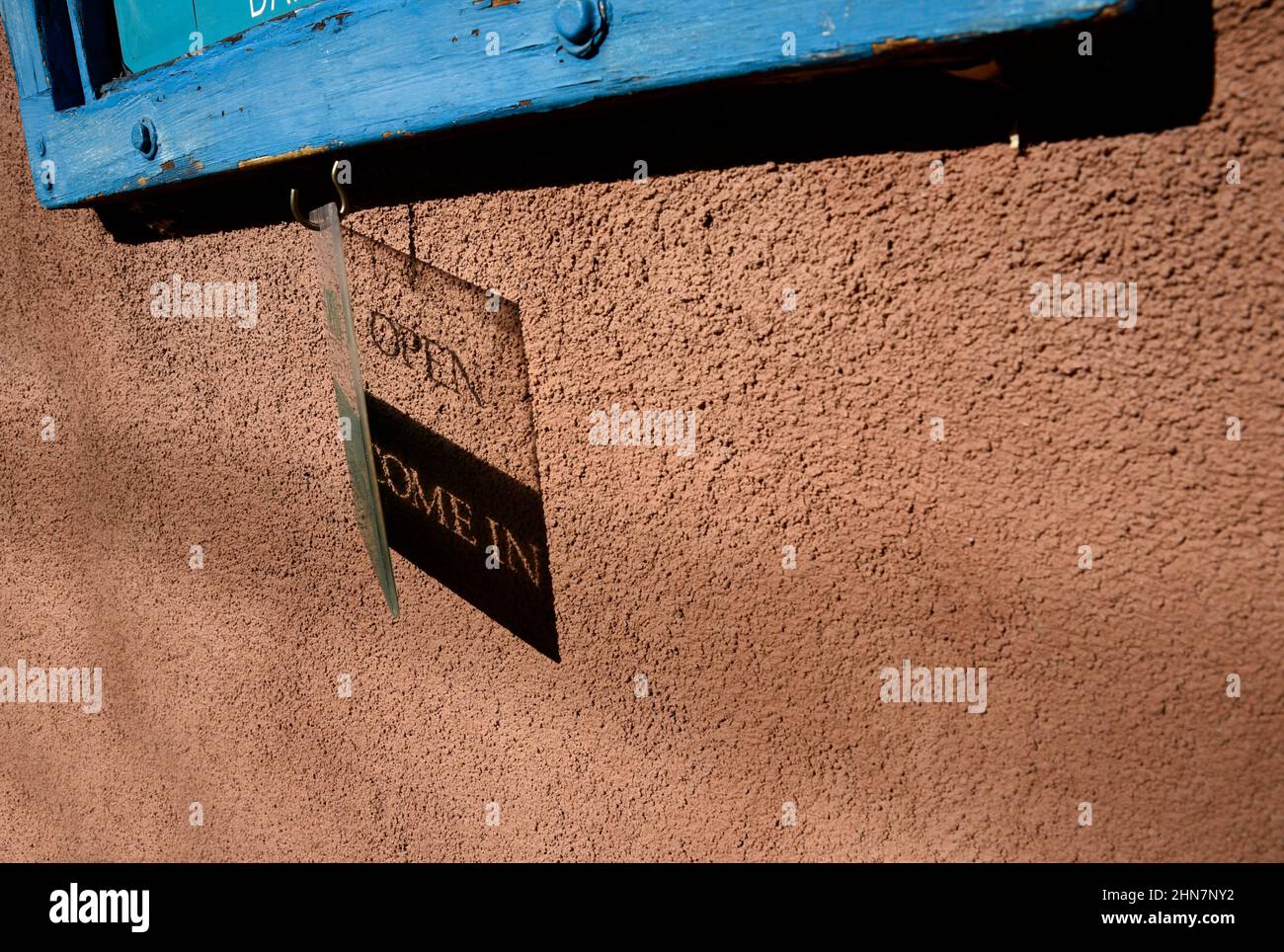 Un panneau en plastique Open projette une ombre sur le mur d'une galerie d'art à Santa Fe, Nouveau-Mexique. Banque D'Images