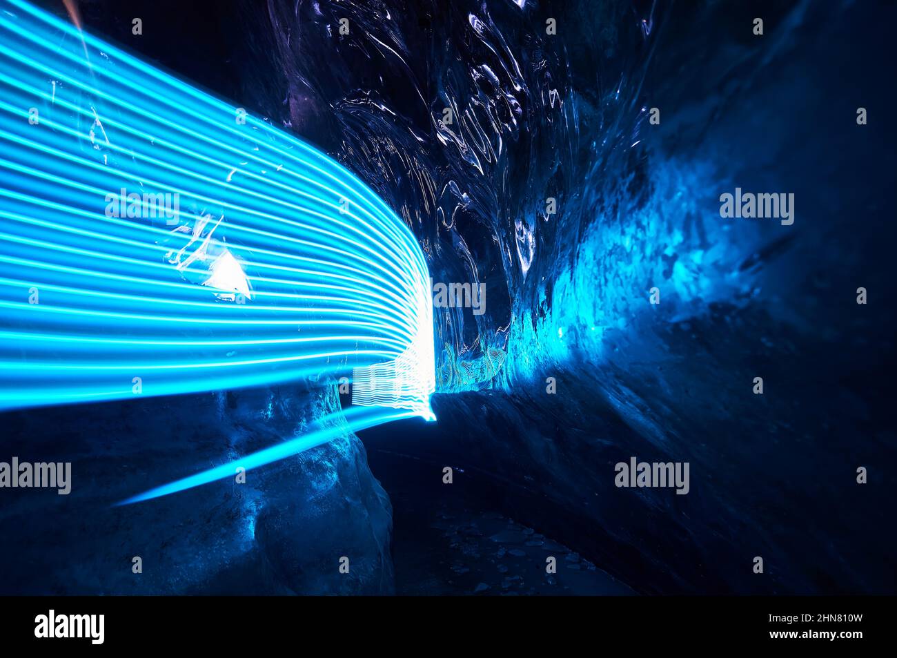 Paysage d'une incroyable grotte de glace glaciaire avec des lumières LED bleues à l'intérieur de la paroi de glace profonde dans le glacier de montagne d'hiver au Kazakhstan Banque D'Images