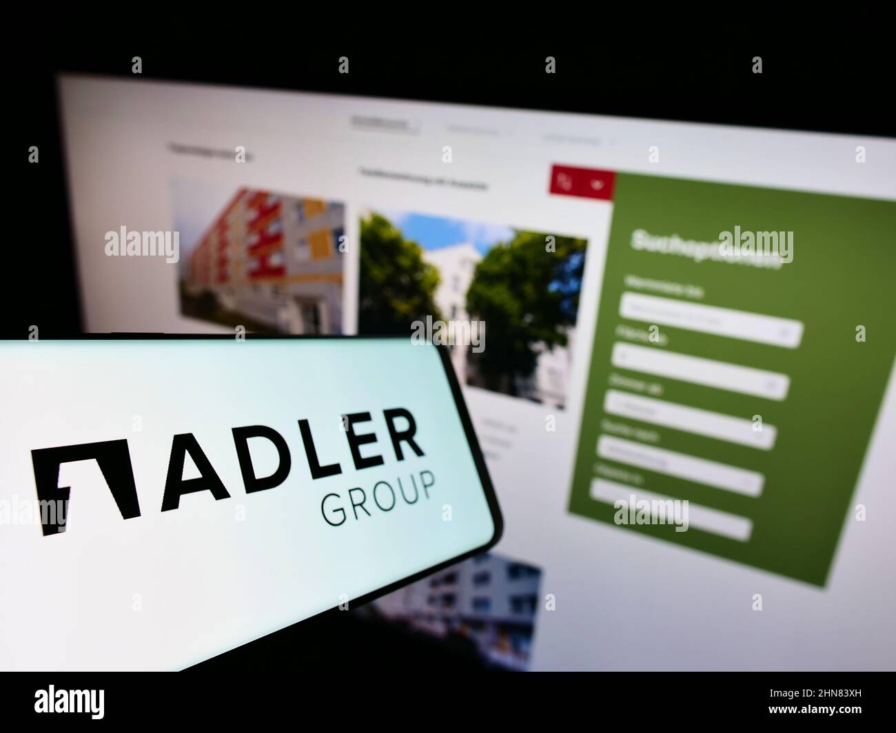 Smartphone avec le logo de la société immobilière Adler Group S.A. sur écran devant le site Web des affaires. Mise au point au centre-gauche de l'écran du téléphone. Banque D'Images