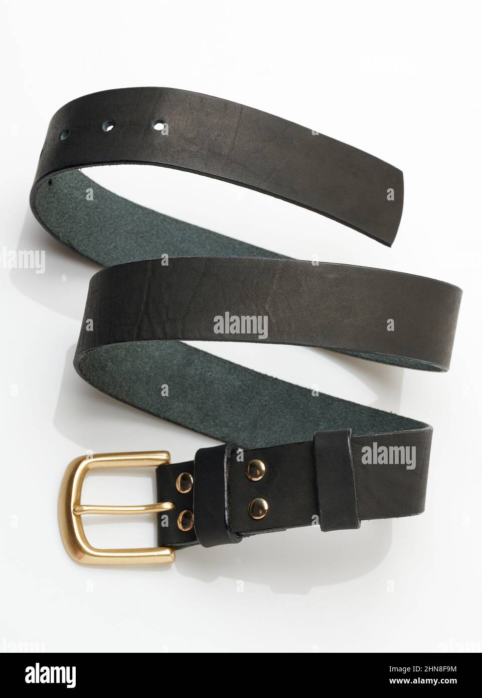 Ceinture en cuir noir en forme de spirale isolée sur le fond du studio Banque D'Images