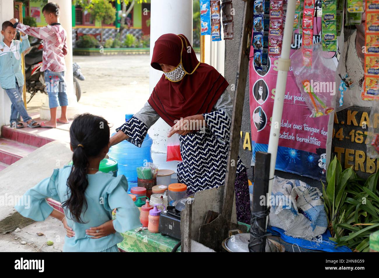 Lampung, Indonésie, décembre 17 2021 - défoqué sur Une mère qui vend des collations dans la cour d'école portant un masque dans une école primaire Banque D'Images