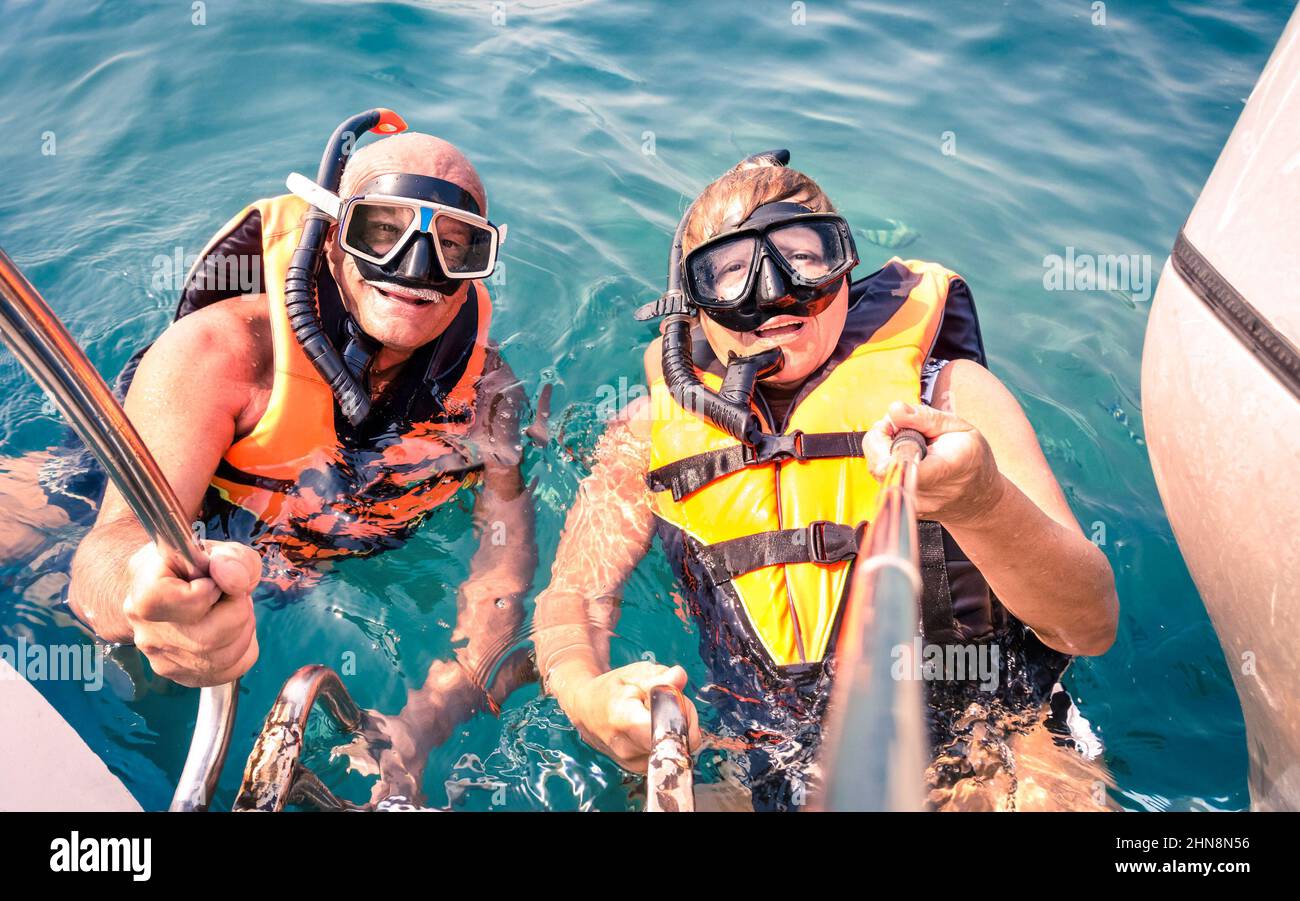 Couple heureux senior utilisant le bâton de selfie dans l'excursion en mer tropicale - excursion en bateau plongée avec tuba dans des scénarios exotiques - concept de personnes âgées actives et de plaisir autour Banque D'Images