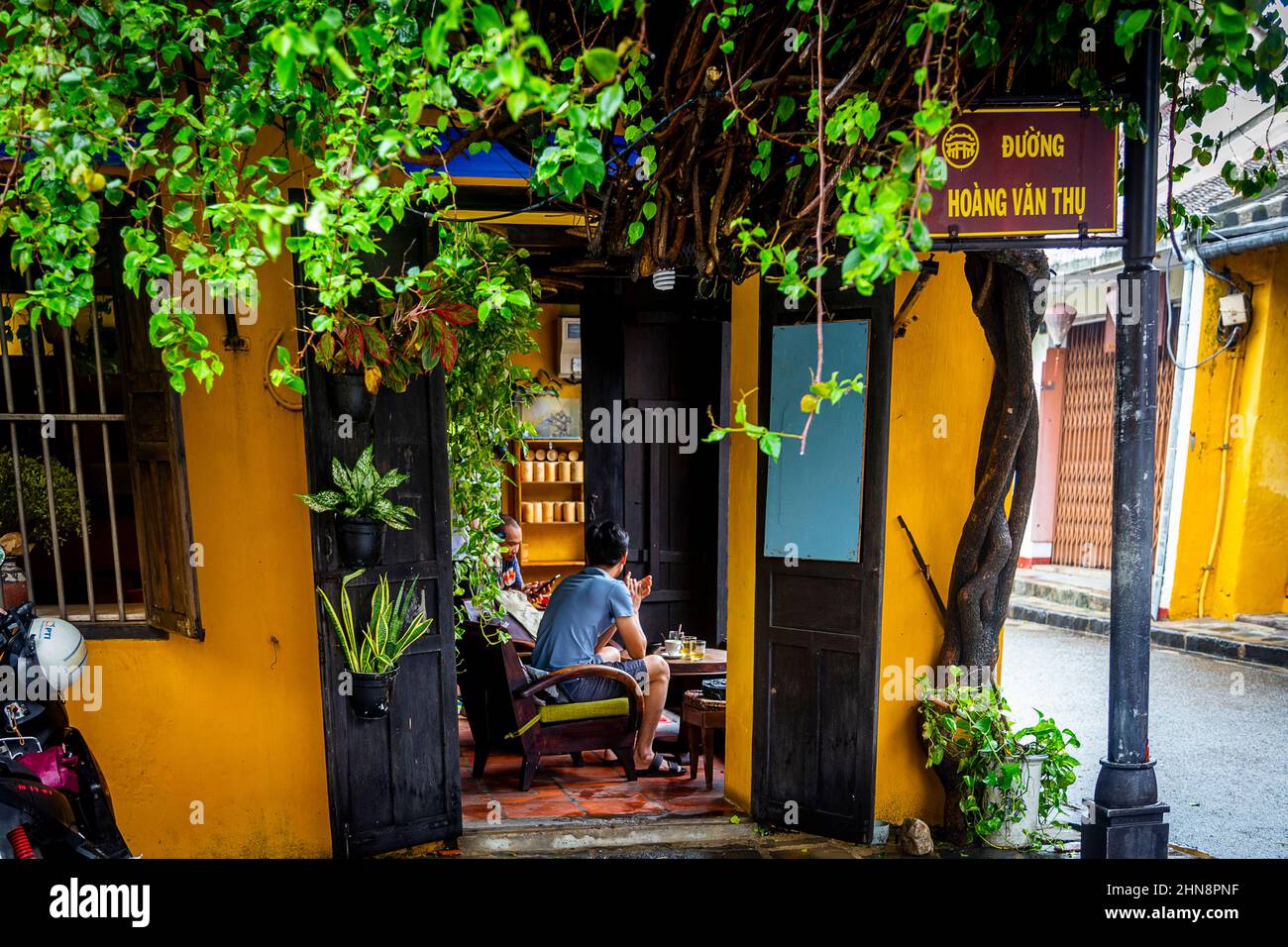 Quelques personnes assises prendre un café dans un petit coin de café dans la vieille ville, Hoi an. Banque D'Images