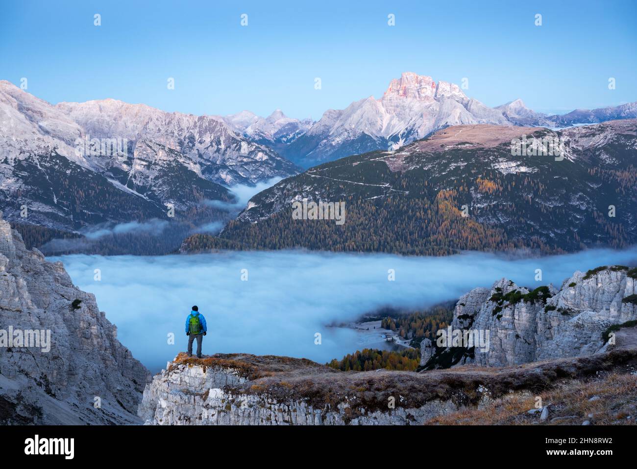 Un touriste se dresse au-dessus du brouillard au bord d'une falaise dans les Dolomites.Emplacement Auronzo rifugio dans le parc national de Tre Cime di Lavaredo, Dolomites, Trentin-Haut-Adige, Italie Banque D'Images