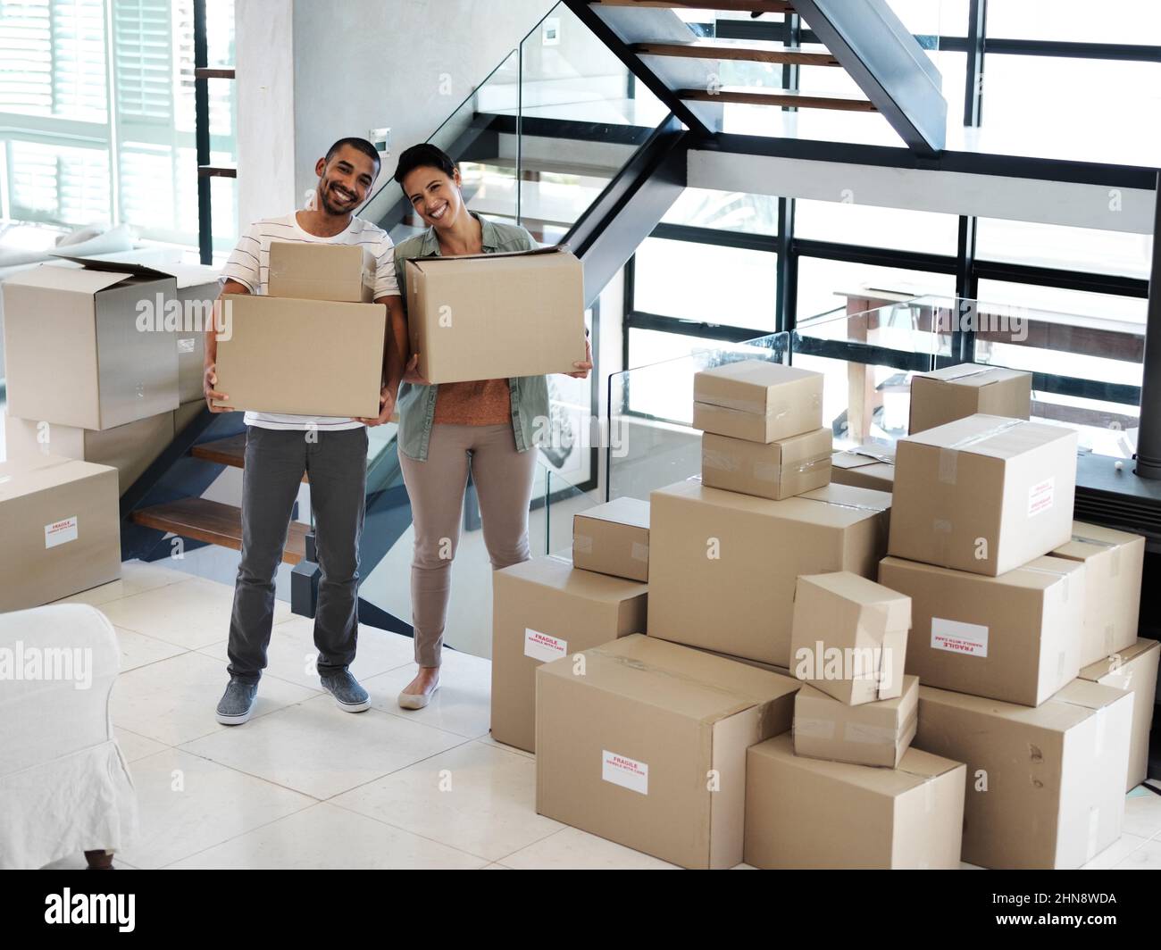 Commencer une nouvelle vie ensemble dans une nouvelle maison. Portrait d'un jeune couple heureux transportant des boîtes tout en se déplaçant dans leur nouvelle maison. Banque D'Images