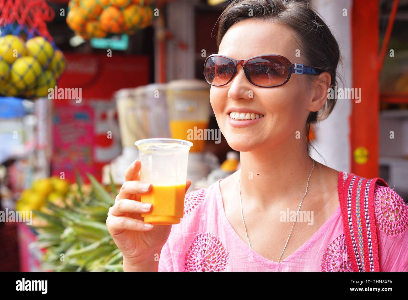 Yougn femme avec un verre de jus de fruits Banque D'Images
