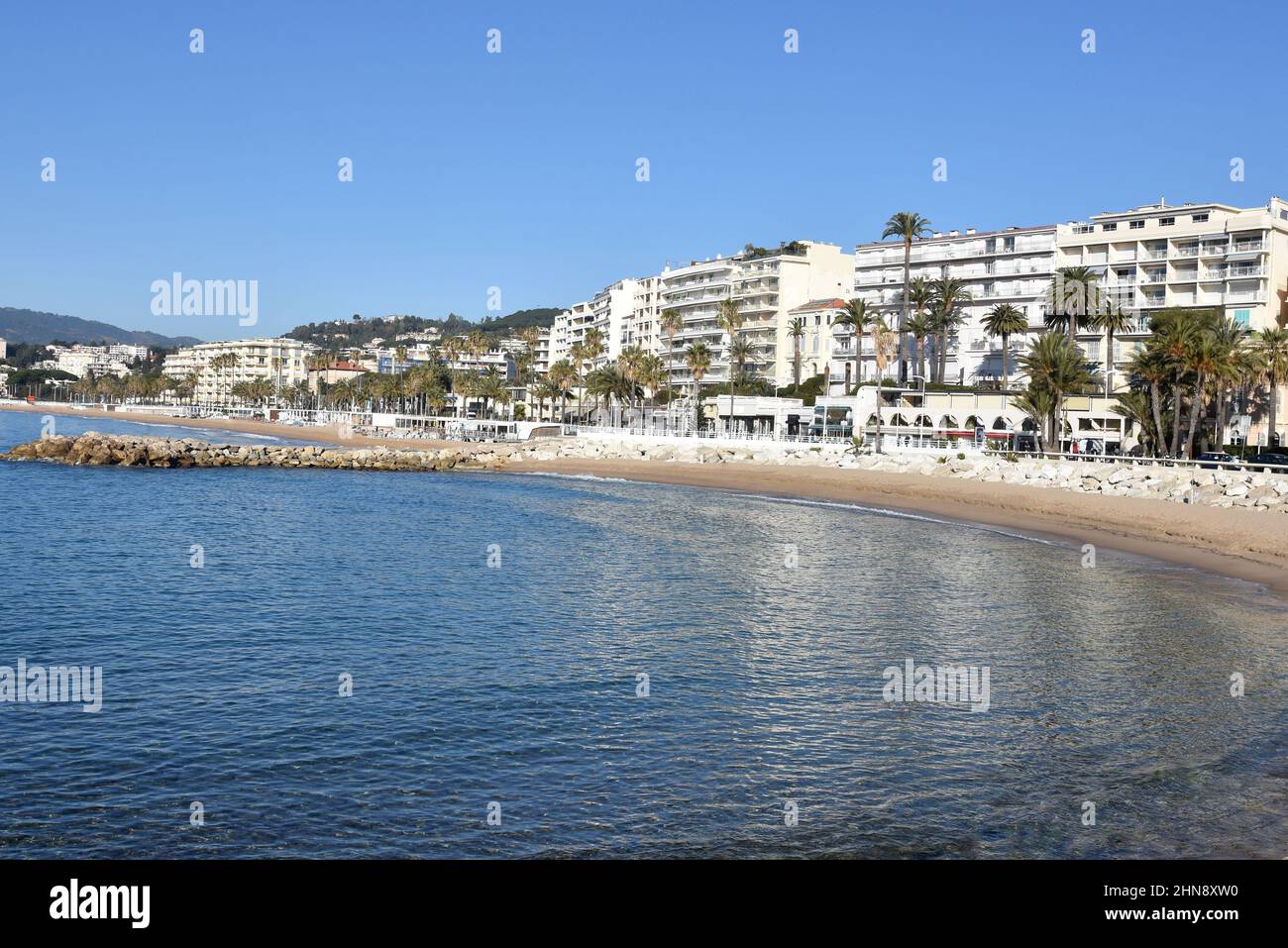 France, côte d'azur, Cannes, le bord de mer sur le boulevard du midi avec ses palmiers et ses plages de sable. Banque D'Images